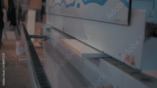 furniture maker glues edge on edgebanding machine photo