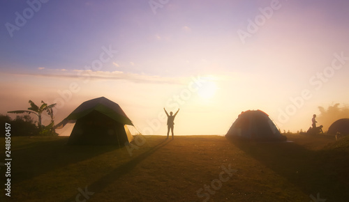 Sunset landscape with silhouette girl and camping tents  orange light