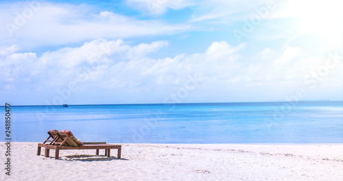 Chairs on the amazing beautiful sandy beach near the ocean with blue sky. Concept of summer leisure calm vacation for a tourism idea. Empty copy space  inspiration of tropical landscape