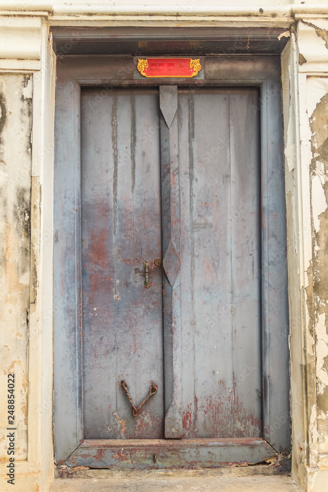 Old ancient weathered double doors in Thai temple. Old ancient weathered double doors in Thai temple.