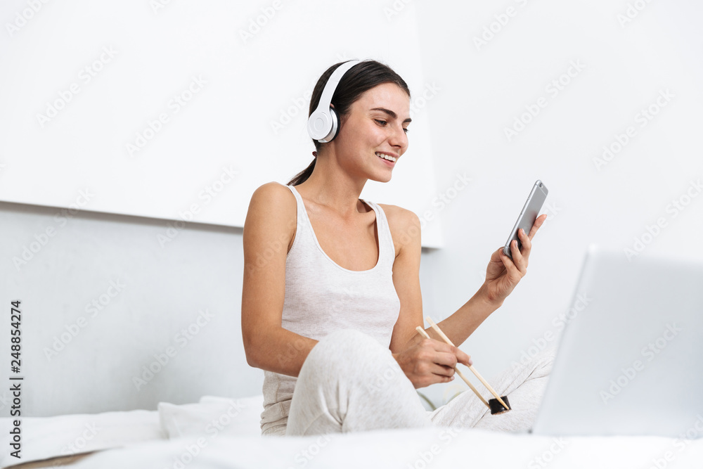 Beautiful young woman relaxing on bed at home Beautiful young woman relaxing on bed at home