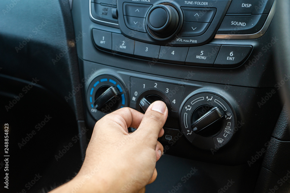 Man turning car air condition controller. Man turning car air condition controller.