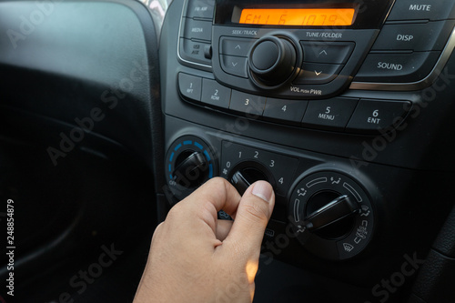 Man turning car air condition controller. 