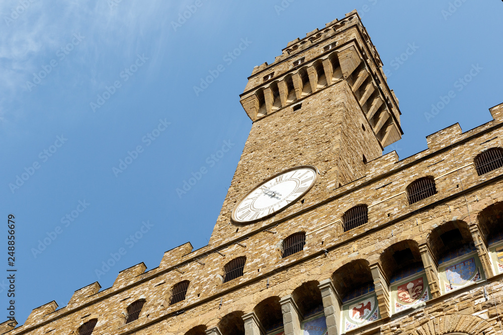 Color DSLR image of the historic landmark Tower of the Palazzo Vecchio, Florence, Italy, against a blue sky. Vertical with copy space for text