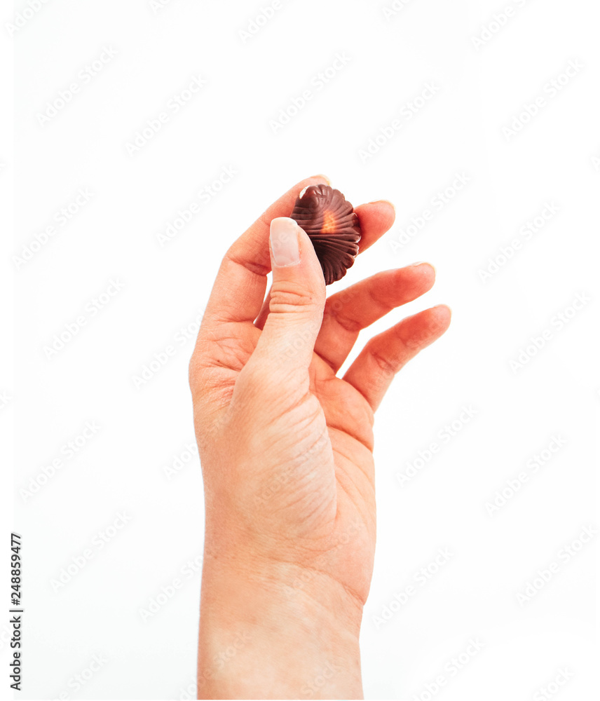 Hand holding Belgian chocolate praline candy, isolated on white background. Hand holding Belgian chocolate praline candy, isolated on white background.