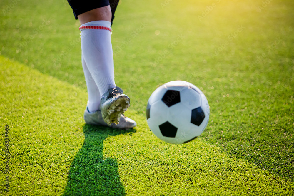 Soccer player speed run to shoot ball to goal on artificial turf