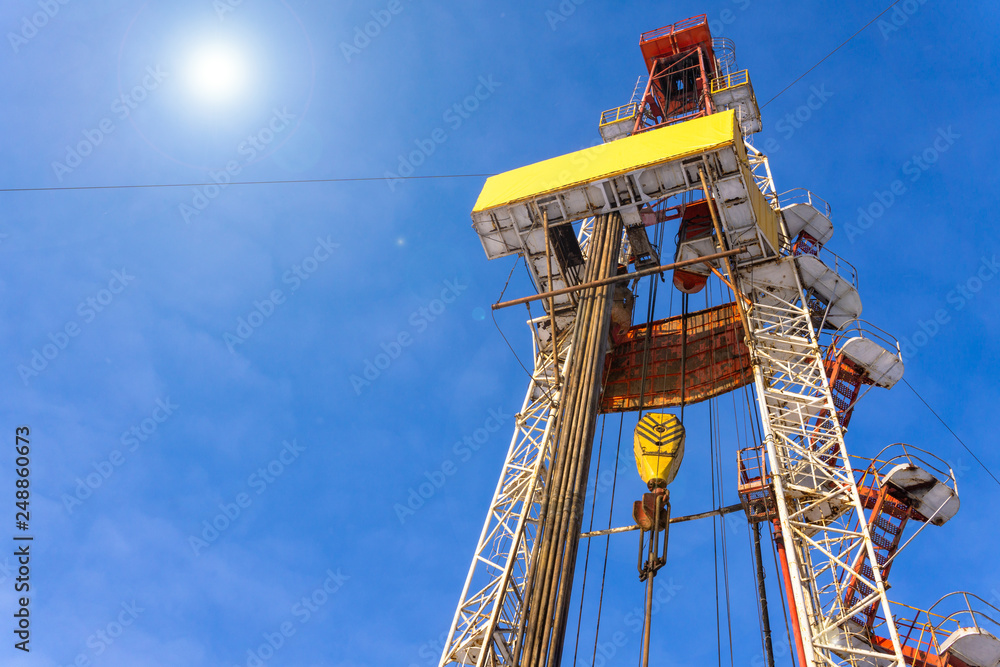 Oil and Gas Drilling Rig onshore dessert with dramatic cloudscape. Oil drilling rig operation on the oil platform in oil and gas industry. Land drilling rig blue sky Oil and Gas Drilling Rig onshore dessert with dramatic cloudscape. Oil drilling rig operation on the oil platform in oil and gas industry. Land drilling rig blue sky