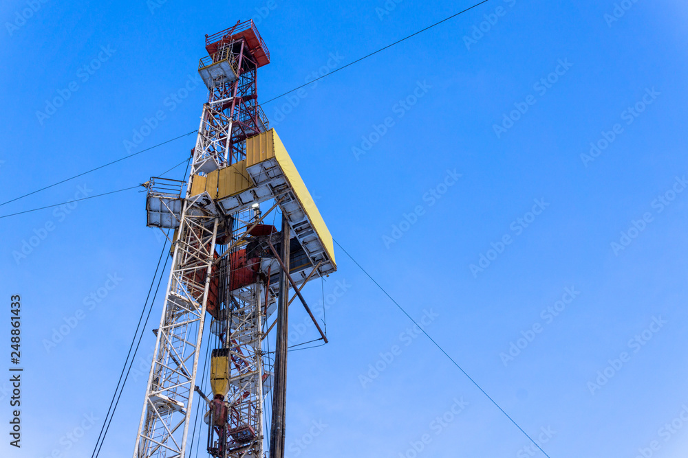 Oil and Gas Drilling Rig onshore dessert with dramatic cloudscape. Oil drilling rig operation on the oil platform in oil and gas industry. Land drilling rig blue sky Oil and Gas Drilling Rig onshore dessert with dramatic cloudscape. Oil drilling rig operation on the oil platform in oil and gas industry. Land drilling rig blue sky