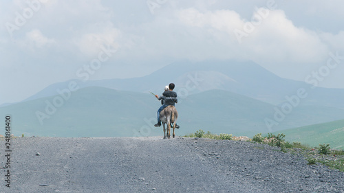 due ragazzi su un asino in montagna photo