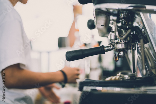 Barista white costume make coffee latte art with espresso coffee machine in cafe restaurant vintage image color tone