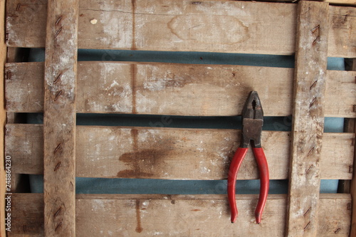 old red pliers on wooden background