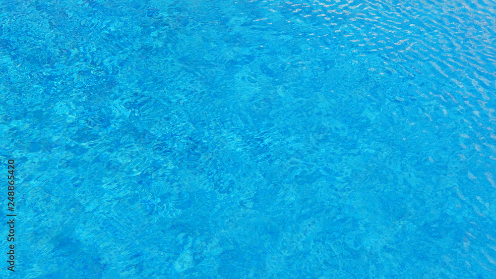 Swimming pool water background with texture of water surface with ripple effect, concept for summer vacation or spa, relaxation or working from anywhere, natural pattern with copy space