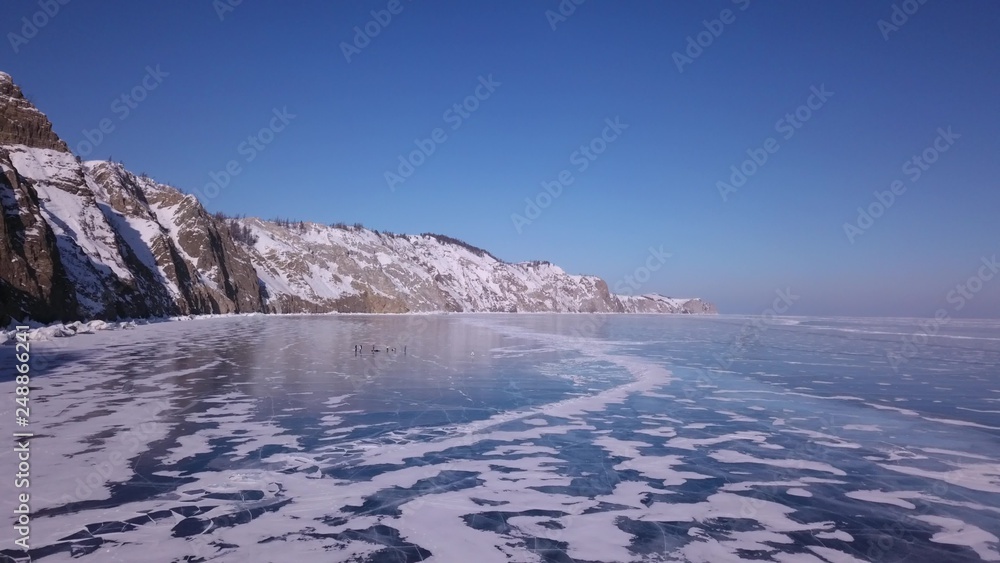 Surface of transparent fissured black ice of The Baikal Lake in winter