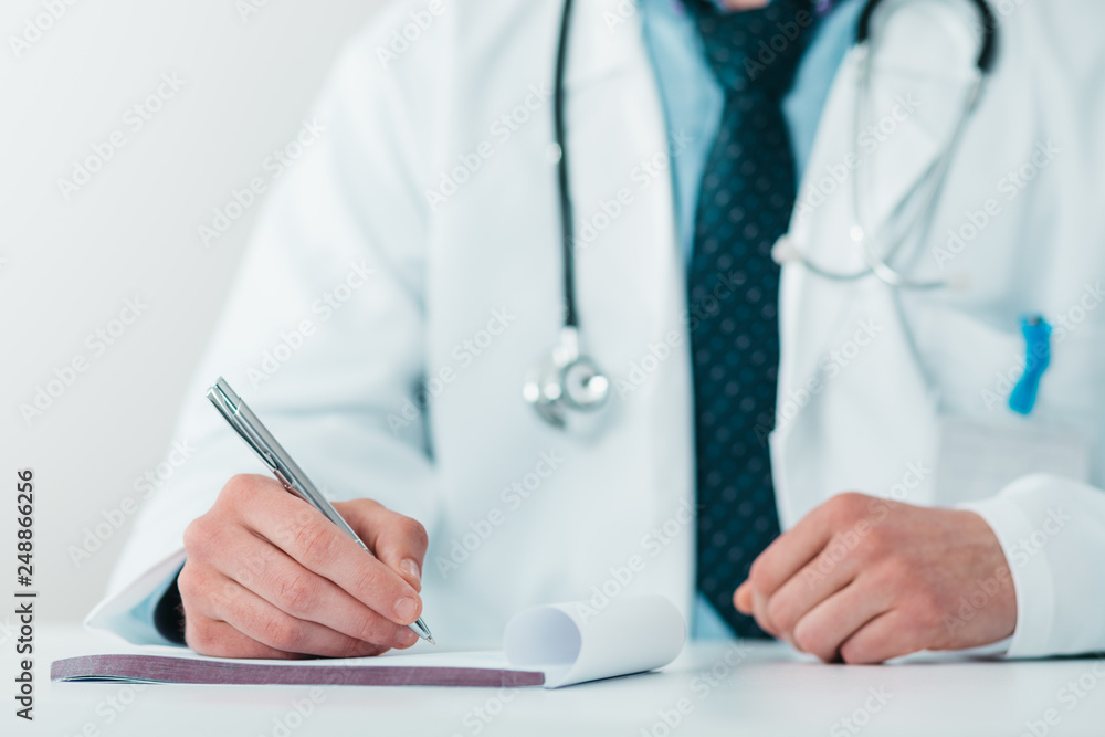 Close up of Young Doctor on the Job writing down diagnosis Close up of Young Doctor on the Job writing down diagnosis