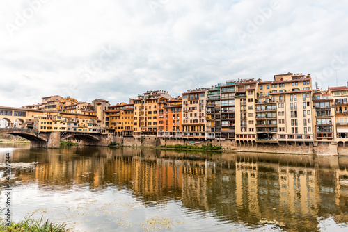 Florence, Italy Firenze orange yellow colorful building on Ponte Vecchio by Arno river during summer morning in Tuscany with nobody and reflection