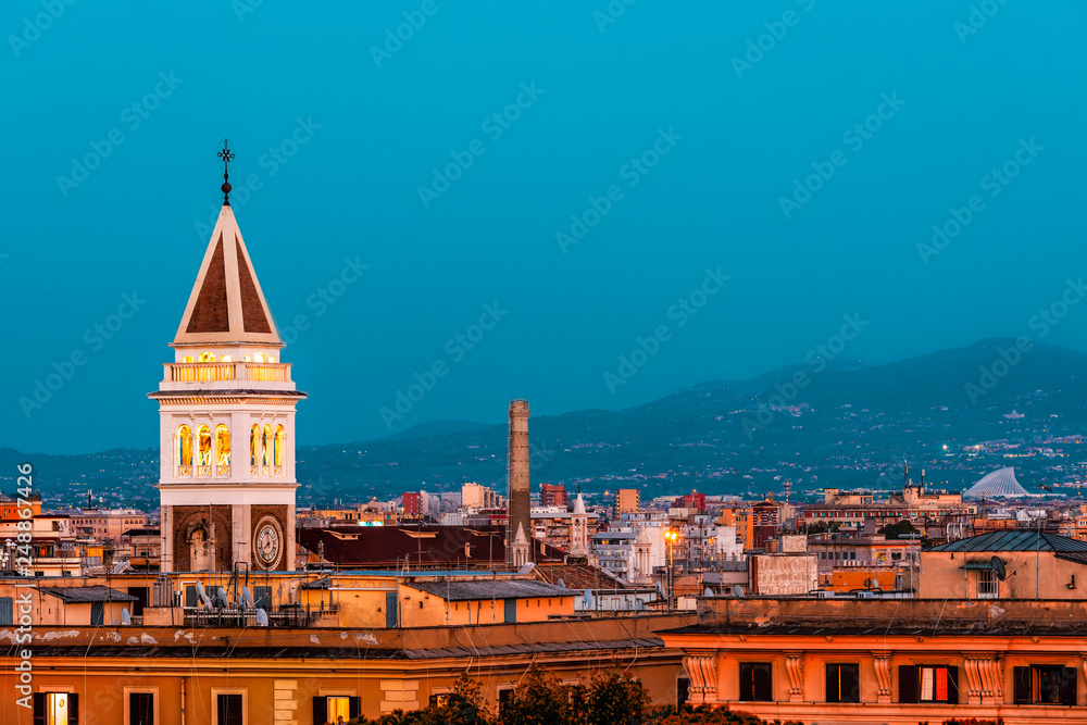 Historic Italian town of San Lorenzo in Rome, Italy cityscape skyline with view of colorful red architecture old buildings church tower at dark blue night