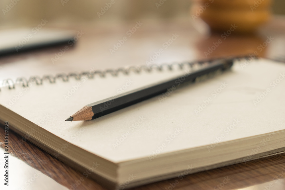 Notebook with drawings and pencil on wooden table. Notebook with drawings and pencil on wooden table.