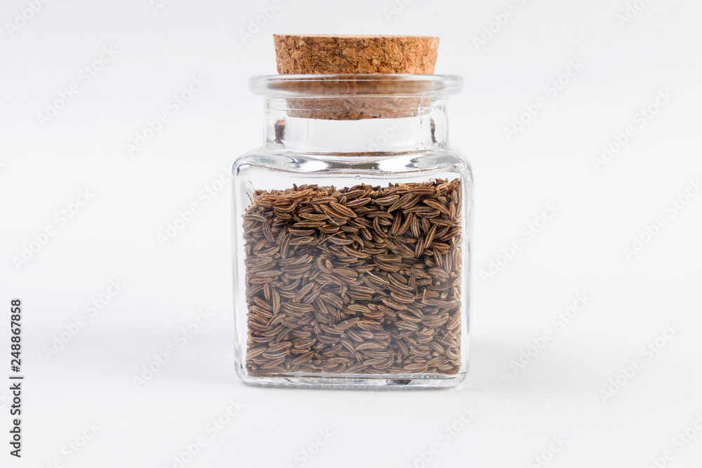 Caraway seeds in a glass jar isolated on white background. Caraway seeds in a glass jar isolated on white background.