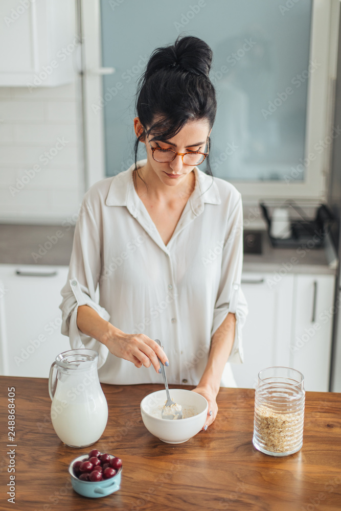 Beautiful young woman making breakfast in the kitchen Beautiful young woman making breakfast in the kitchen