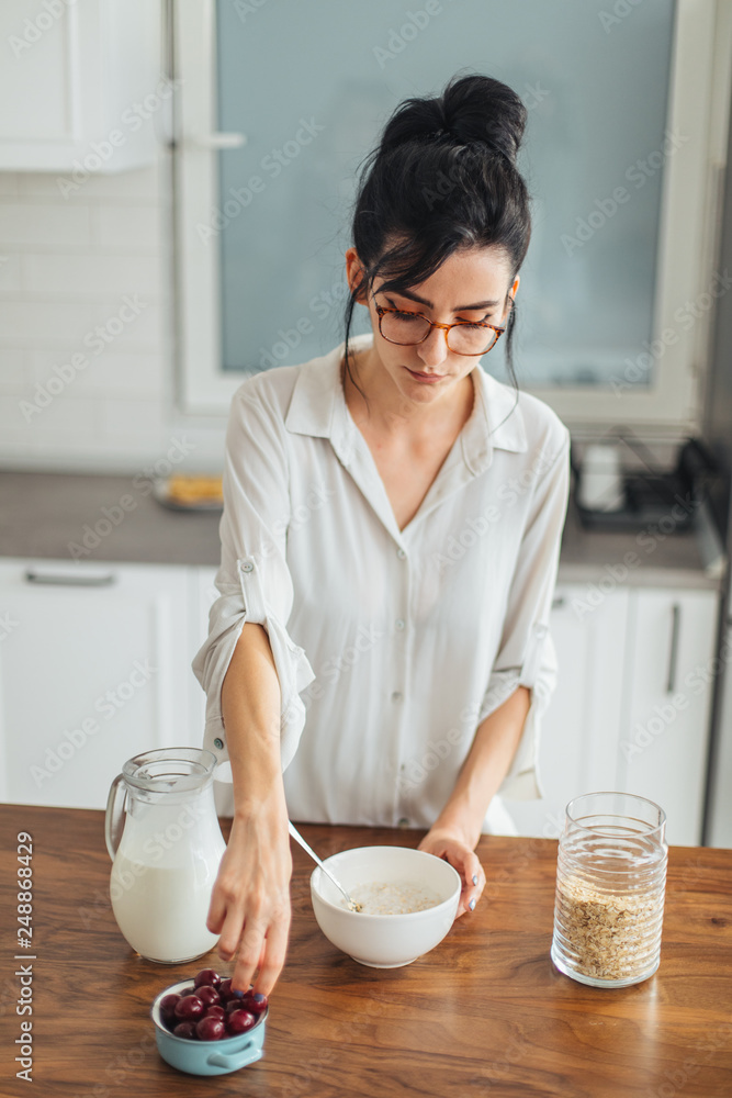 Beautiful young woman making breakfast in the kitchen Beautiful young woman making breakfast in the kitchen