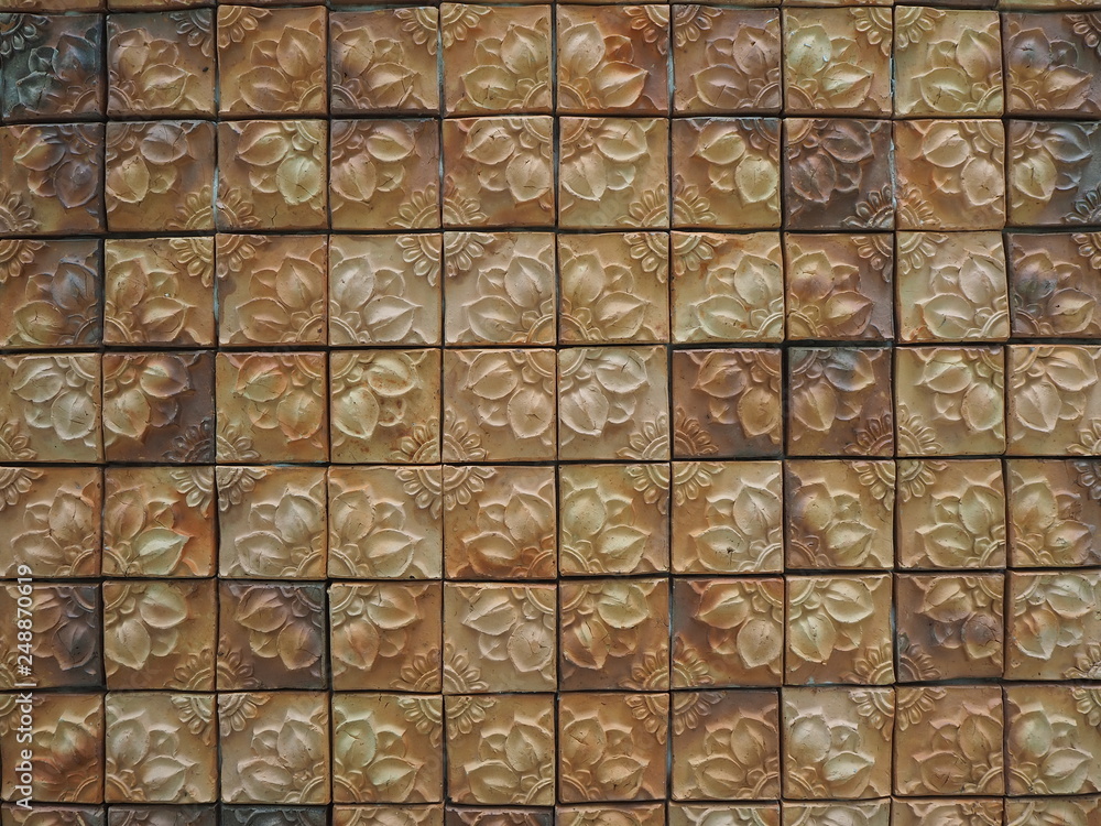 Flower patterned clay tiles decorated on leather and have a beautiful texture as the background. Flower patterned clay tiles decorated on leather and have a beautiful texture as the background.