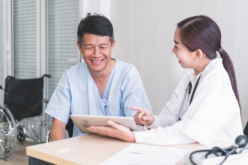 Woman doctors are explaining something from a tablet to a sick male patient. Woman doctors are explaining something from a tablet to a sick male patient.