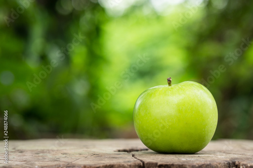 One green apple on wooden background.