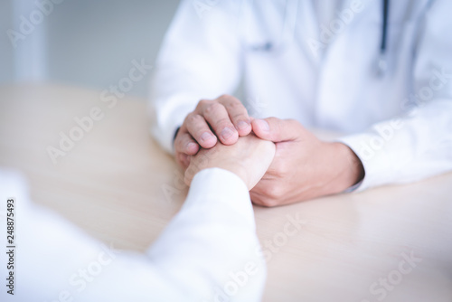 Doctor holds hands for patients to encourage.