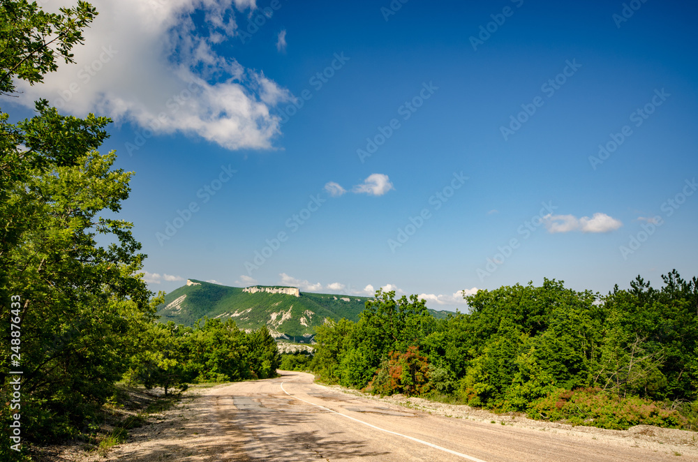 Ukrainian Crimean rural road under blue sky summer sunny day