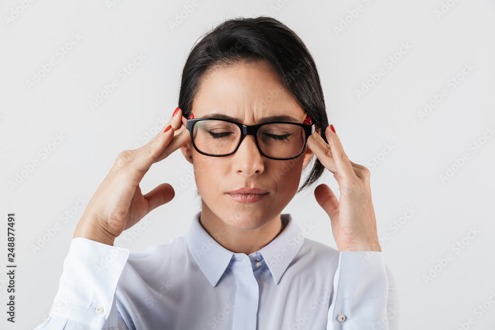Image closeup of uptight secretary woman wearing eyeglasses standing in the office, isolated over white background Image closeup of uptight secretary woman wearing eyeglasses standing in the office, isolated over white background