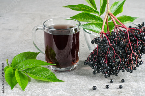 Glass with elderberry drink and ripe berries