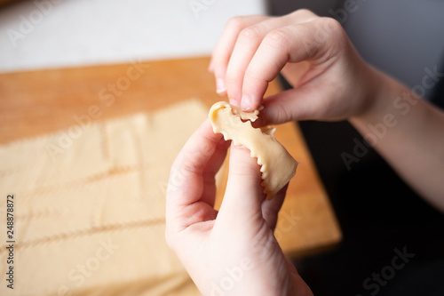 Dłonie przewijają ciasto surowe na faworek
