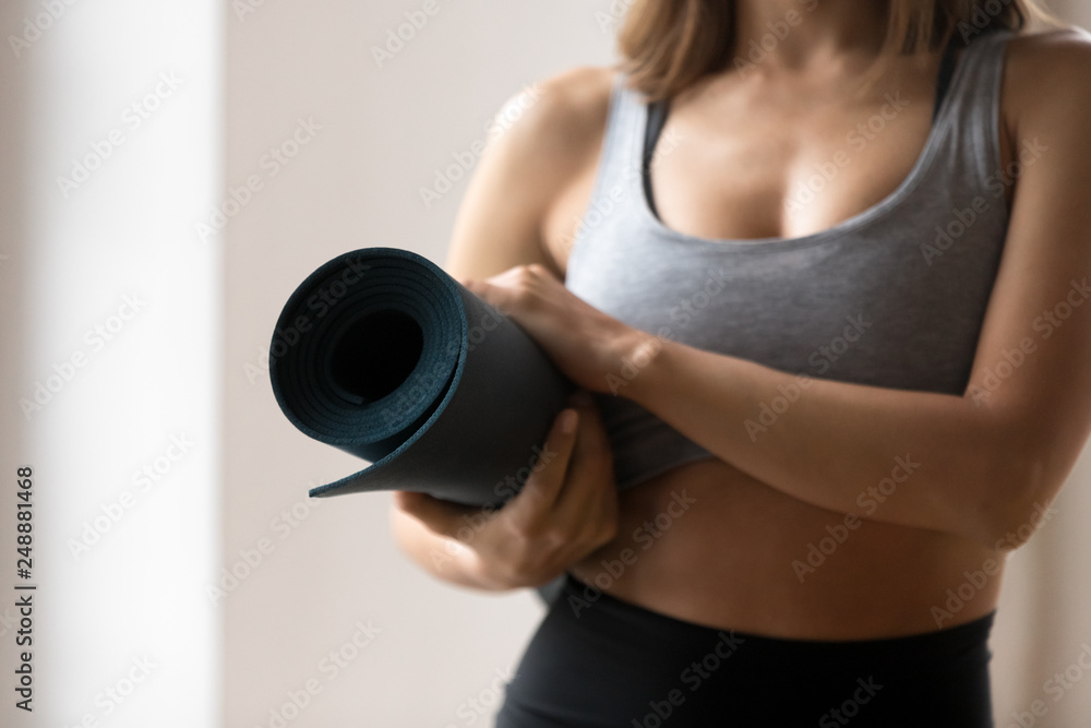 Toned woman holding mat ready for yoga workout Toned woman holding mat ready for yoga workout