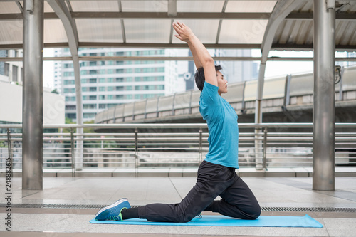 Young man sitting exercise with pose yoga meditation on blue mat