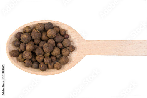 allspice on wooden spoon isolated on white background