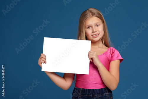 Portrait of adorable emotional little girl on blue background