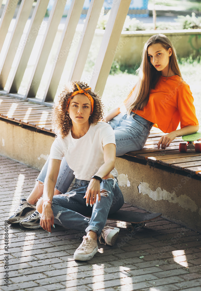 Foto Stock Two girls dressed in the style of 80s hippie pose in the park |  Adobe Stock