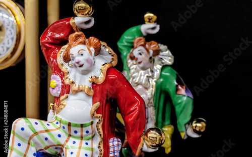 Porcelain figurine of a clown juggling gold balls.