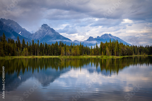 Mountains reflecting in the calm waters of Spillway Lake in Peter Lougheed Provincial Park, Alberta, Canada