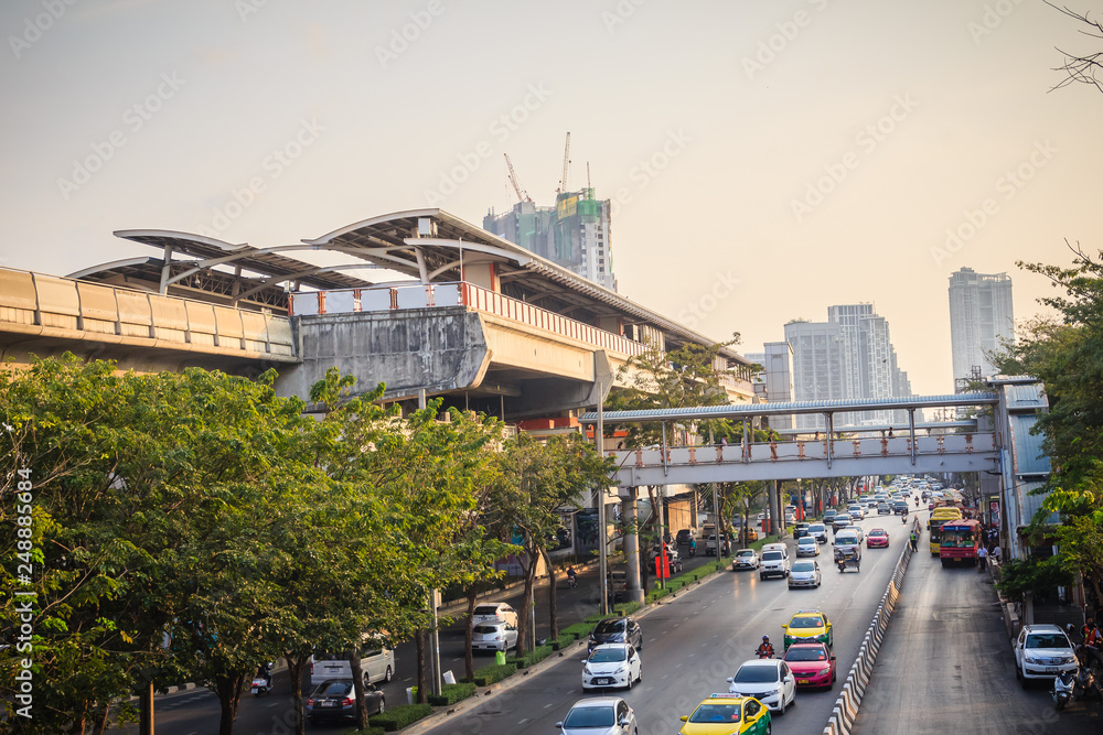 Bangkok, Thailand - March 8, 2017:  Traffic on the Phahon Yothin Road interchange of Mochit BTS sky train station and Chatuchak MRT subway station with crowd of people waiting for buses and taxis.
