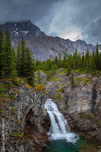 A small waterfall in the Canadian Rocky Mountains on a grey rainy day, Alberta, Canada © Tom Nevesely