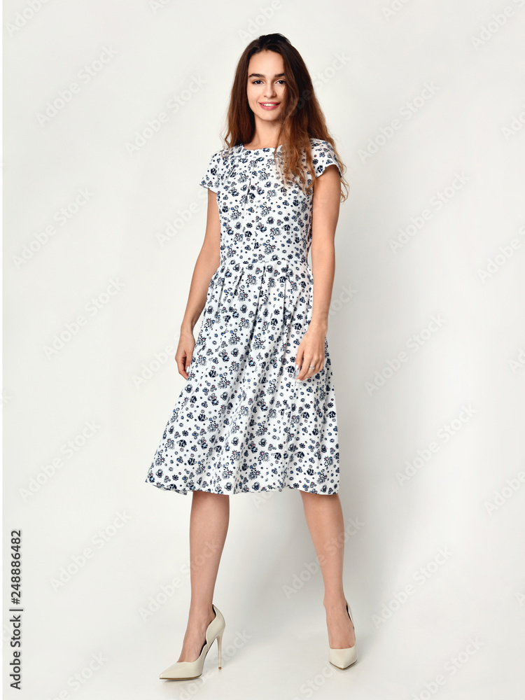 Young beautiful woman posing in new design casual summer dress on grey Young beautiful woman posing in new design casual summer dress on grey