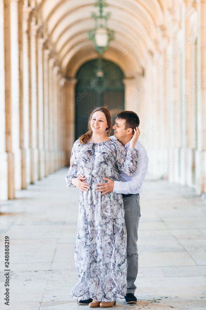 Fototapeta premium The guy hugs the girl from the back side and looks at her in the