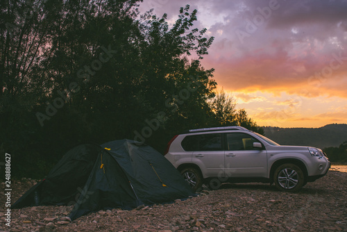 camping at rivershore on sunrise. white suv car