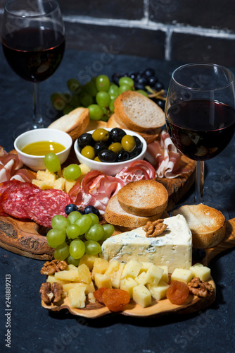 cheese platter, bread, fruit and cold cuts to wine, vertical closeup