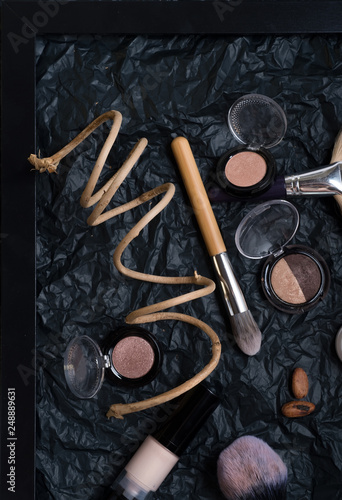 set of cosmetics and nature chocolate on black background in frame