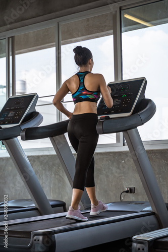 beautiful asian girl is walking on a treadmill in the gym.She Send your eyes with pleasure in exercise because it makes her shapely, the concept of exercise, lose weight, strengthen muscles.