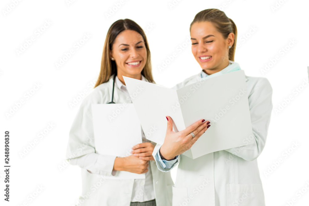 Cheerful female doctors reading results isolated on the white Cheerful female doctors reading results isolated on the white