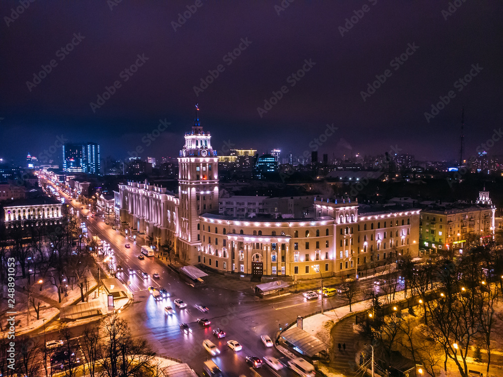 Arial view of famous Voronezh building with tower in night, symbol of Voronezh and evening cityscape with rads, parks and traffic, drone shot