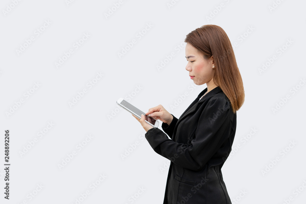 Happy asian business woman using tablet device in black suit isolated on white color background Happy asian business woman using tablet device in black suit isolated on white color background